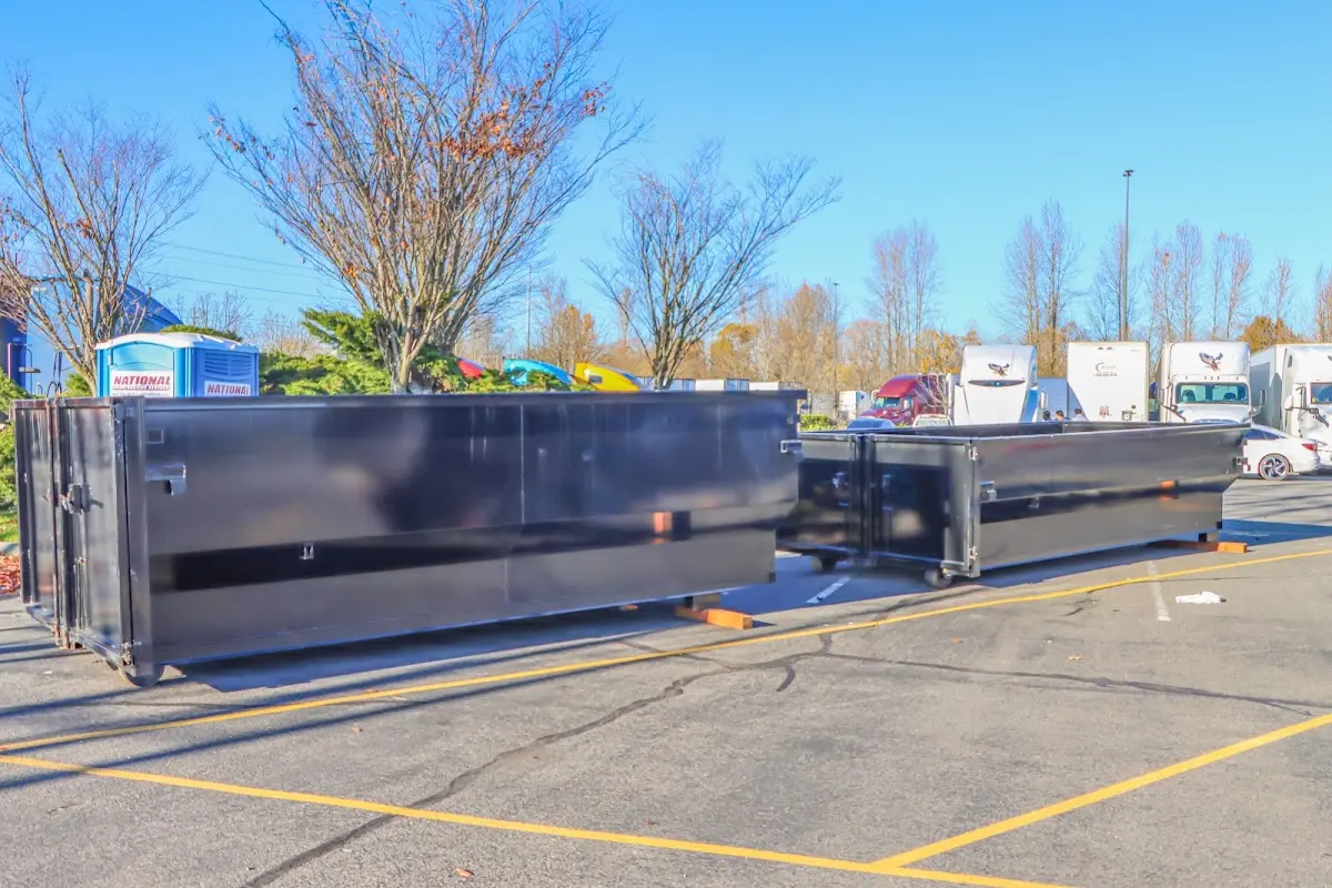 Professional dumpster rental service with roll-off container on residential driveway in Brighton